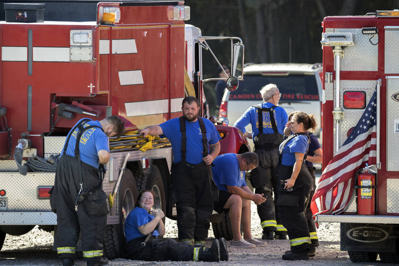 Members with the Waynesville Fire and Rescue Department take a break from battling large fire that ...