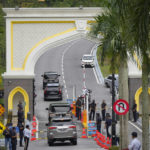 
              A representative from Barisan National (BN) arrives by car at National Palace in Kuala Lumpur, Malaysia to meet with King Sultan Abdullah Sultan Ahmad Shah Wednesday, Nov. 23, 2022. Malaysia's king on Tuesday failed to reach a decision on whom to pick as prime minister after meeting the leaders of two rival blocs, and summoned lawmakers from a political bloc that has held out its support. (AP Photo/Vincent Thian)
            