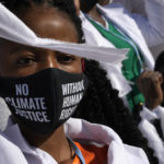 
              A girl wears a mask that reads "no climate justice without human rights" during a silent protest at the COP27 U.N. Climate Summit, Thursday, Nov. 10, 2022, in Sharm el-Sheikh, Egypt. (AP Photo/Peter Dejong)
            