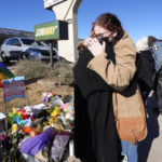 
              Ashlyn May, left, is hugged by Reese Congleton as they stop at the display of flowers on a corner near the site of a mass shooting at a gay bar Monday, Nov. 21, 2022, in Colorado Springs, Colo. (AP Photo/David Zalubowski)
            