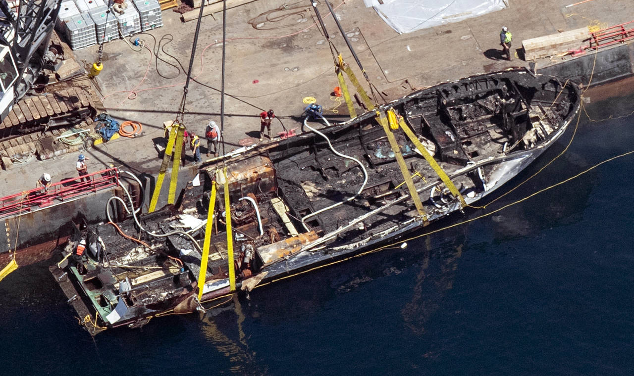 FILE - The burned hull of the dive boat Conception is brought to the surface by a salvage team off ...