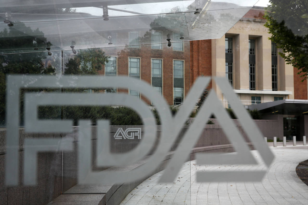 FILE - The U.S. Food and Drug Administration building stands behind an FDA logo at a bus stop on th...