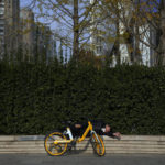 
              FILE - A man wearing a face mask rests outside the shuttered commercial office buildings at the central business district as part of COVID-19 controls in Beijing, Nov. 22, 2022. (AP Photo/Andy Wong, File)
            