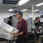 
              Workers organize vote-by-mail ballots for scanning during the midterm election at the Miami-Dade County Elections Department, Tuesday, Nov. 8, 2022, in Miami. (AP Photo/Lynne Sladky)
            