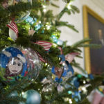 
              Ornaments containing self-portraits of students from across the country hang from a tree in the State Dining Room of the White House during a press preview of holiday decorations at the White House, Monday, Nov. 28, 2022, in Washington. (AP Photo/Patrick Semansky)
            