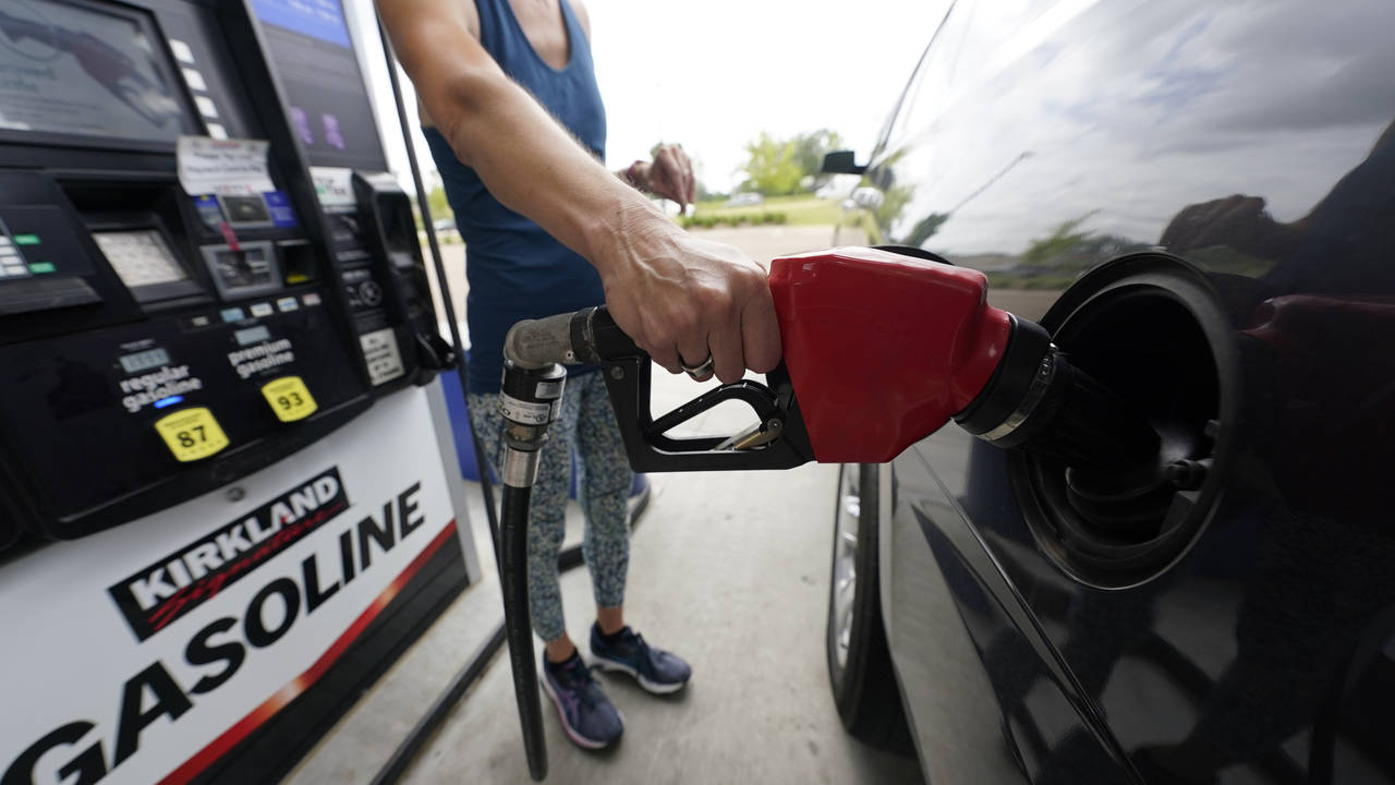Photo: A customer readies to pump gas as carbon auctions impact prices....