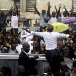
              Ivory Coast's former youth minister Charles Ble Goude is cheered by supporters upon his return to Abidjan, Ivory Coast, Saturday Nov. 26, 2022, after more than a decade in exile. Ble Goude was acquitted of charges linked to the violence that erupted after the disputed 2010 election when then President Laurent Gbagbo refused to concede. (AP Photo/Diomande Bleblonde)
            
