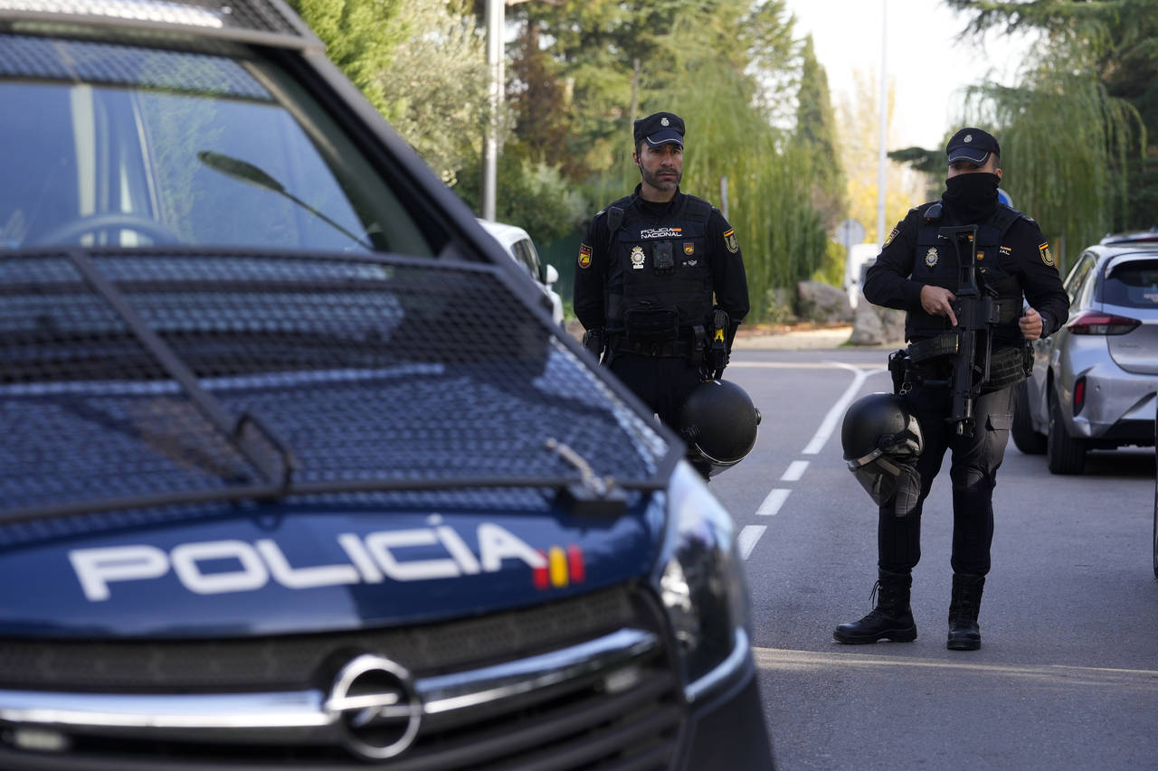 Police officers stand guard as they cordon off the area next to the Ukrainian embassy in Madrid, Sp...