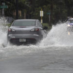 
              A car tries to navigate a flooded A1A just south of Dania Beach Blvd. as Tropical Storm Nicole continues to move towards our coast on Wednesday, Nov. 9, 2022 in Hollywood Beach, Fla.  (Mike Stocker/South Florida Sun-Sentinel via AP)
            