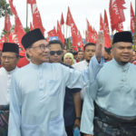 
              Malaysian opposition leader Anwar Ibrahim, center left, waves at his supporters as he arrives at a nomination center for the upcoming general election in Tambun, Malaysia, Saturday, Nov. 5, 2022. Campaigning for Malaysia’s general elections formally started Saturday, in a highly competitive race that will see the world’s longest-serving coalition seeking to regain its dominance four years after a shocking electoral loss. (AP Photo/JohnShen Lee)
            