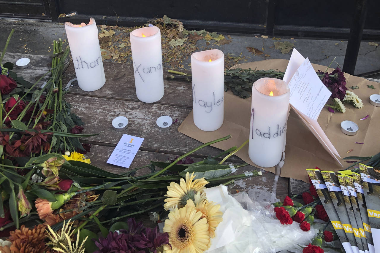 Candles and flowers are left at a make-shift memorial honoring four slain University of Idaho stude...