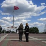 
              FILE - People look as a replica of the Victory banner flutters in the wind over the central square in Melitopol, Zaporizhzhia region, in territory under Russian military control, southeastern Ukraine, on May 1, 2022. As Russians seized parts of eastern and southern Ukraine in the 8-month-old war, mayors, civilian administrators and others, including nuclear power plant workers, say they have been abducted, threatened or beaten to force their cooperation. In some instances, they have been killed. Human rights activists say these actions could constitute a war crime. (AP Photo, File)
            
