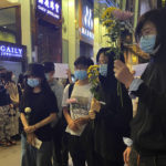 
              Residents hold up flowers to commemorate victims of a recent Urumqi deadly fire in Central in Hong Kong, Monday, Nov. 28, 2022. Students in Hong Kong chanted “oppose dictatorship” in a protest against China’s anti-virus controls after crowds in mainland cities called for President Xi Jinping to resign in the biggest show of opposition to the ruling Communist Party in decades. (AP Photo/Zen Soo)
            