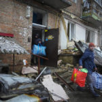 
              People gather their belongings from a damaged house after Russian shelling in the town of Vyshgorod outside the capital Kiev, Ukraine, Thursday, Nov. 24, 2022. About 70% of the Ukrainian capital was left without power on Thursday morning after Moscow unleashed yet another devastating missile barrage on Ukraine's energy infrastructure, Kyiv's mayor said. (AP Photo/Efrem Lukatsky)
            
