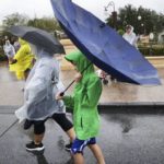 
              Winds blow an umbrella inside-out as guests leave the Magic Kingdom at Walt Disney World in Lake Buena Vista, Fla., Wednesday, Nov. 9, 2022, as conditions deteriorate with the approach of Hurricane Nicole. All 4 Disney parks in Central Florida closed early Wednesday because of the impending storm. (Joe Burbank/Orlando Sentinel via AP)
            
