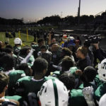 
              West Bloomfield team members huddle as defensive line coach Justin Ibe leads a team prayer before the game against Eisenhower, Friday, Oct. 21, 2022, in West Bloomfield, Mich. Across America, most high school football seasons are winding down. It will wrap up the first year since the Supreme Court ruled it was OK for a public school coach near Seattle to pray on the field. (AP Photo/Carlos Osorio)
            