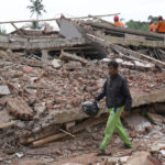 
              Enjot, 45, who lost his house and few relatives, walks past the rubble of a building collapsed in Monday's earthquake in Cianjur, West Java, Indonesia Tuesday, Nov. 22, 2022. Rescuers on Tuesday struggled to find more bodies from the rubble of homes and buildings toppled by an earthquake that killed a number of people and injured hundreds on Indonesia's main island of Java. (AP Photo/Tatan Syuflana)
            