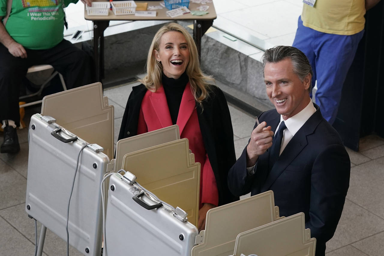 California Gov. Gavin Newsom and his wife, first partner Jennifer Siebel Newsom laugh as they pause...