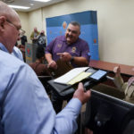 
              Clark County Registrar of Voters Joe Gloria, center, speaks with reporters at a news conference at the Clark County Election Department, Wednesday, Nov. 9, 2022, in Las Vegas. (AP Photo/Gregory Bull)
            