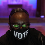 
              A poll worker wears a "vote" mask as they check in voters on Election Day, Tuesday, Nov. 8, 2022, in Atlanta. (AP Photo/Brynn Anderson)
            
