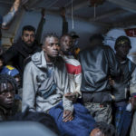 
              Migrants sit on the deck of the Rise Above rescue ship run by the German organization Mission Lifeline, in the Mediterranean Sea off the coasts of Sicily, southern Italy, Sunday, Nov. 6, 2022. Italy allowed one rescue ship, the German run Humanity 1, to enter the Sicilian port and begin disembarking minors, but refused to respond to requests for safe harbor from three other ships carrying 900 more people in nearby waters. (Severine Kpoti/Mission Lifeline Via AP)
            