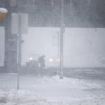 
              A person waits at a bus stop as snow falls on Friday, Nov. 18, 2022, in Buffalo, N.Y.  A dangerous lake-effect snowstorm paralyzed parts of western and northern New York, with nearly 2 feet of snow already on the ground in some places and possibly much more on the way. (AP Photo/Joshua Bessex)
            