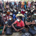 
              Ethnic Rohingya people sit at a temporary shelter in North Aceh, Indonesia, Wednesday, Nov. 16, 2022. Over 100 Rohingya Muslims traveling in a wooden boat have landed on an Indonesian beach, the second group in as many days to arrive in the island nation's northernmost province of Aceh. (AP Photo/Zik Maulana)
            