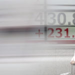 
              A person stands in front of an electronic stock board showing Japan's Nikkei 225 index at a securities firm as a car passing by Monday, Nov. 7, 2022, in Tokyo. Asian stocks mostly rose Monday, as investors weighed uncertainties such as the U.S. mid-term elections and China's possible moves to ease coronavirus restrictions. (AP Photo/Eugene Hoshiko)
            