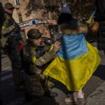 
              A Ukrainian defence force member signs a Ukrainian flag to a resident in Kherson, southern Ukraine, Monday, Nov. 14, 2022. The retaking of Kherson was one of Ukraine's biggest successes in the nearly nine months since Moscow's invasion. (AP Photo/Bernat Armangue)
            