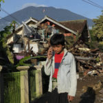 
              A boy talks on his mobile phone near houses damaged in Monday's earthquake in Cianjur, West Java, Indonesia, Thursday, Nov. 24, 2022. The 5.6 magnitude earthquake left hundreds dead, injures and missing as buildings crumbled and terrified residents ran for their lives on Indonesia's main island of Java. (AP Photo/Tatan Syuflana)
            
