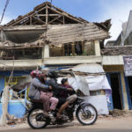 
              People ride a motorbike past a building damaged in Monday's earthquake in Cianjur, West Java, Indonesia, Tuesday, Nov. 22, 2022. Rescuers on Tuesday struggled to find more bodies from the rubble of homes and buildings toppled by an earthquake that killed a number of people and injured hundreds on Indonesia's main island of Java. (AP Photo/Tatan Syuflana)
            