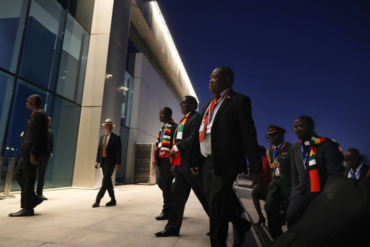 President Emmerson Mnangagwa, of Zimbabwe, center, walks to the plenary session of the COP27 U.N. C...