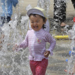 
              Children play in the water to cool off at a park in Yokohama, near Tokyo, Tuesday, Aug. 18, 2020. The number of babies born in Japan in 2022 is below last year’s record low in what the the top government spokesman described as a “critical situation.” (AP Photo/Koji Sasahara)
            