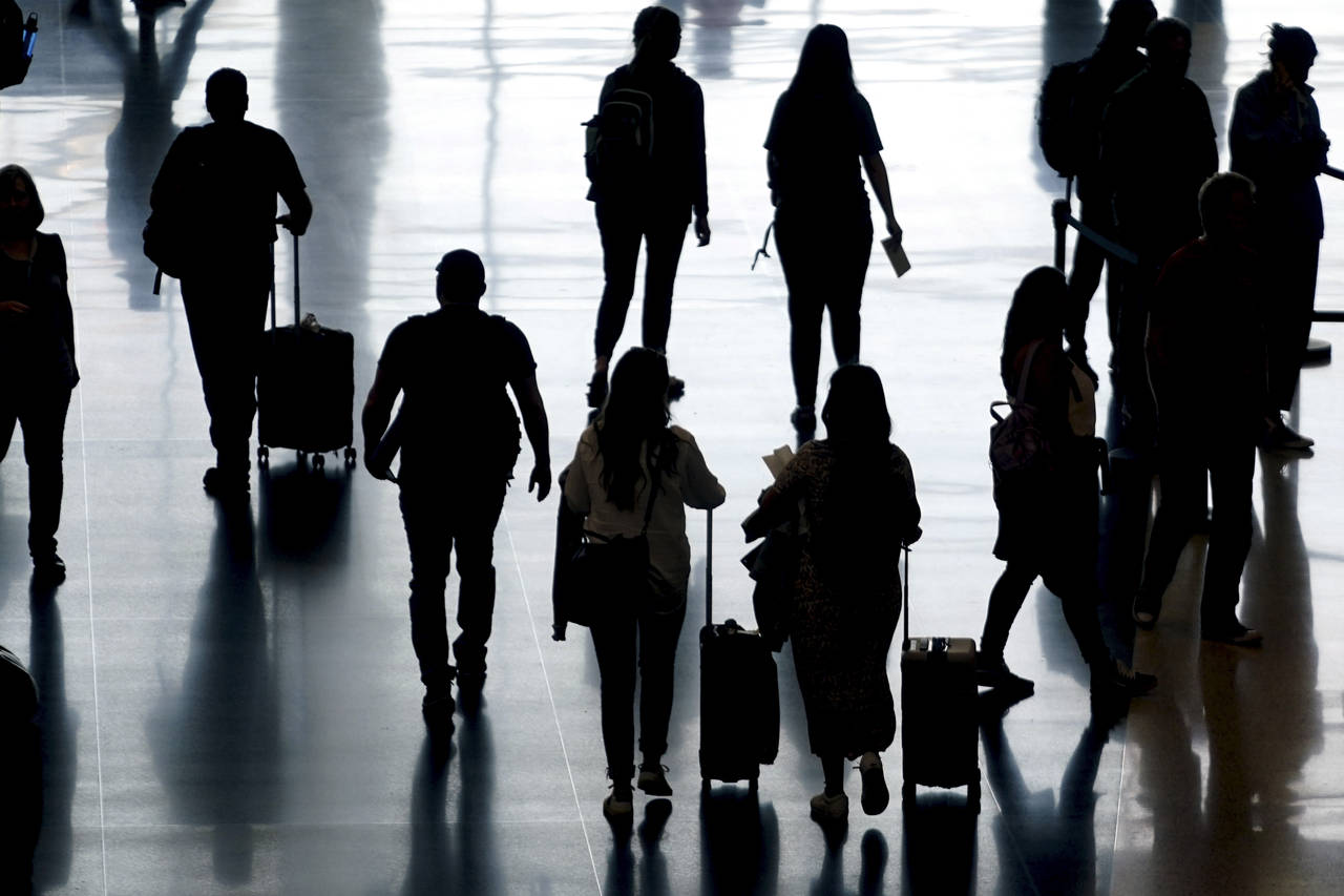 FILE - People pass through Salt Lake City International Airport on June 27, 2022, in Salt Lake City...