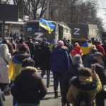 
              FILE - People with Ukrainian flags walk towards Russian army trucks during a rally against the Russian occupation in Kherson, Ukraine, March 20, 2022. Russia relinquished its final foothold in a major city in southern Ukraine on Friday Nov. 11, 2022, clearing the way for victorious Ukrainian forces to reclaim the country’s only Russian-held provincial capital that could act as a springboard for further advances into occupied territory. (AP Photo/File)
            