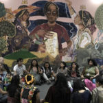 
              Indigenous people hold hands in a circle backdropped by a mural by Indian artist and founder of Fearless Collective Shilo Shiv Suleman at the COP27 U.N. Climate Summit, Wednesday, Nov. 16, 2022, in Sharm el-Sheikh, Egypt. (AP Photo/Nariman El-Mofty)
            