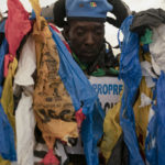 
              The environmental activist Modou Fall, who many simply call "Plastic Man", wears his uniform before an event about environmental health and pollution management in Dakar, Senegal, Tuesday, Nov. 8, 2022. As he walks, plastics dangle from his arms and legs, rustling in the wind while strands drag on the ground. On his chest, poking out from the plastics, is a sign in French that says, "No to plastic bags." (AP Photo/Leo Correa)
            