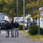 
              Law enforcement personnel walk on the scene where two officers were reported shot, Tuesday, Nov. 1, 2022, in Newark, N.J. Two officers were being treated for injuries at a nearby hospital, according to the Essex County prosecutor's office. (AP Photo/Seth Wenig)
            