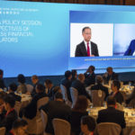 
              Governor of the People's Bank of China Yi Gang, right, speaks via video during the Global Financial Leaders' Investment Summit in Hong Kong, Wednesday, Nov. 2, 2022. Chinese regulators downplayed China's real estate slump and slowing economic growth while Hong Kong's top leader pitched Hong Kong as a unique link to the rest of China at a high-profile investment summit Wednesday. (AP Photo/Bertha Wang)
            