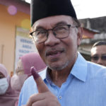 
              Malaysian opposition leader Anwar Ibrahim shows his inked finger after voting at a polling station in Seberang Perai, Penang state, Malaysia, Saturday, Nov. 19, 2022. Malaysians began casting ballots Saturday in a tightly contested national election that will determine whether the country's longest-ruling coalition can make a comeback after its electoral defeat four years ago. (AP Photo/Vincent Thian)
            