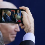 
              A man records President Joe Biden during a visit to the technology company Viasat, Friday, Nov. 4, 2022, in Carlsbad, Calif. (AP Photo/Gregory Bull)
            