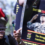 
              Demonstrators stage a protest against the release on parole of Janusz Walus, convicted killer of South African anti-apartheid leader Chris Hani, seen in an April 1993 image on the poster, in Pretoria, South Africa, Wednesday, Nov. 30, 2022. Walus was stabbed in prison, two days before he was due to be released on parole, prison authorities said Tuesday. (AP Photo)
            