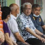 
              Malaysian caretaker Prime Minister Ismail Sabri Yaakob, second from right, waits in a line with other voters to cast his ballots at a polling station during the 15th Malaysian general election in Bera, Pahang, Malaysia, Saturday, Nov. 19, 2022. Malaysians began casting ballots Saturday in a tightly contested national election that will determine whether the country's longest-ruling coalition can make a comeback after its electoral defeat four years ago. (AP Photo/Ahmad Yusni)
            