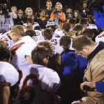 
              FILE - Bremerton High School assistant football coach Joe Kennedy, center in blue, kneels and prays after his team lost to Centralia in Bremerton, Wash., Oct. 16, 2015. Across America, most high school football seasons are winding down. It will wrap up the first year since the Supreme Court ruled it was OK for a public school coach near Seattle to pray on the field. (Lindsey Wasson/The Seattle Times via AP, File)
            