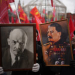 
              Communist party supporters hold portraits of Josef Stalin and Vladimir Lenin as they gather during the national celebration of the "Defender of the Fatherland Day" near the Kremlin in Moscow's Revolution Square on Feb. 23, 2022. (AP Photo/Alexander Zemlianichenko)
            