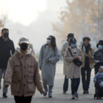
              People wearing face masks walk along a pedestrian shopping street at the Wangfujing shopping district in Beijing, Saturday, Nov. 19, 2022. Performances have been suspended at one of Beijing's oldest and most renowned theaters amid a new wave of shop and restaurant closures in response to a spike in COVID-19 cases in the Chinese capital. (AP Photo/Mark Schiefelbein)
            
