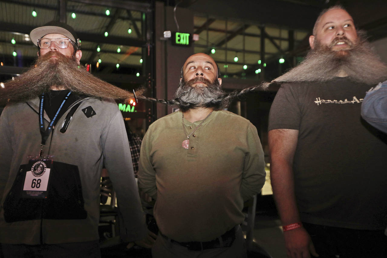 Men wait for the chain of their beards to be measured as part of their attempt at breaking the worl...
