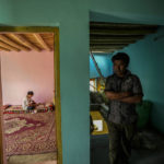 
              Konchok Dorjey walks toward a room in his home where his daughter Rigzen Angmo reads in Kharnakling near Leh town in the cold desert region of Ladakh, India, Friday, Sept. 16, 2022. (AP Photo/Mukhtar Khan)
            