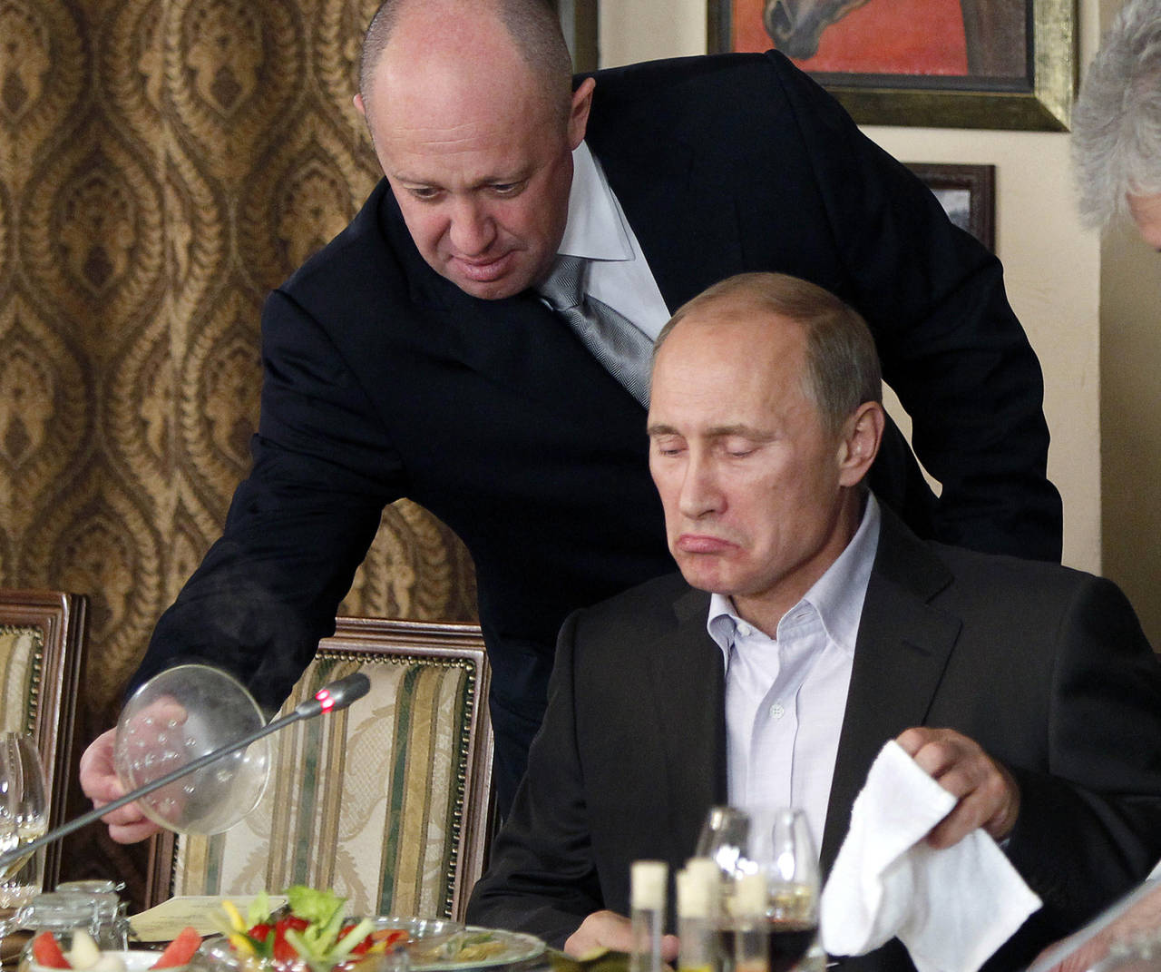 FILE - Yevgeny Prigozhin, top, serves food to then-Russian Prime Minister Vladimir Putin at Prigozh...
