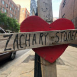 
              In this May 22, 2019 photo, a makeshift cross marking the spot where Zachary Stoner was killed on May 30, 2018, in a drive-by shooting in downtown Chicago. Chicago police documents obtained by The Associated Press show investigators believe they solved the 2018 killing of a gangland journalist known as “ZackTV” but that prosecutors declined to prosecute. Police never announced arrests in the downtown shooting of Zachary Stoner. But the documents say five “Perry Avenue” gang members were arrested within a year of the killing on probable cause of murder.  (AP Photo/Michael Tarm)
            